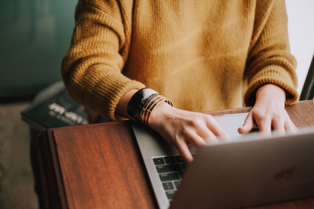 Photo of a woman typing on a laptop.